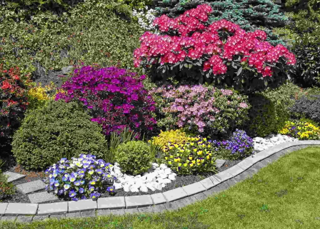 Curved flower bed bursting with color beside a neatly trimmed lawn in Greenville, SC.